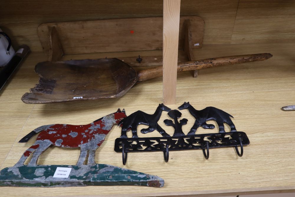 A 19th century sycamore grain shovel, 98cm., a beech wall shelf and two painted sheet metal ornaments